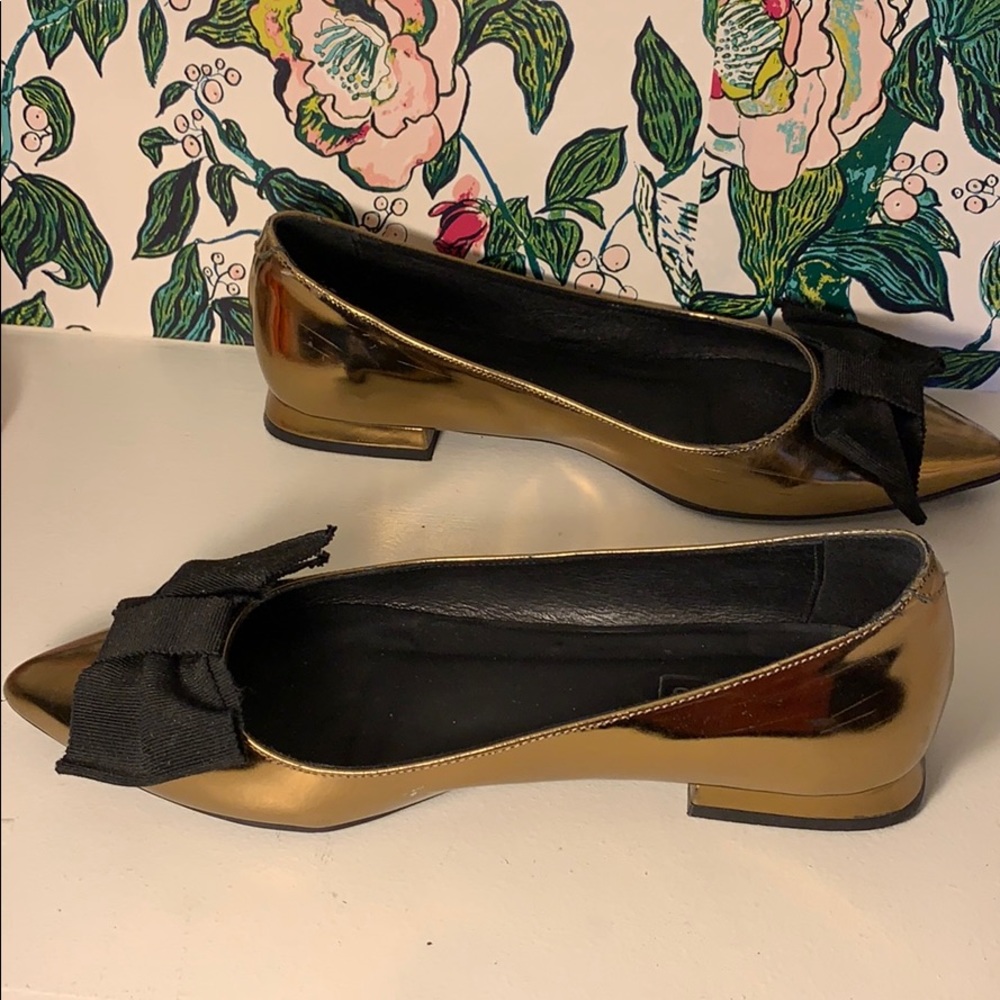 Gold Anthropologie flats with black bow
